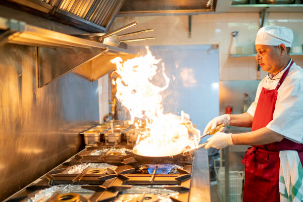 istock Indian chef cooking in industrial kitchen with the burning pan 1384289004