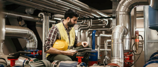 istock Technician engineer man in uniform with tablet checking and control boiler tanks and liquid pipeline in production line at factory 1384290707