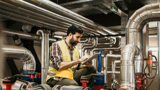 istock Technician engineer man in uniform with tablet checking and control boiler tanks and liquid pipeline in production line at factory 1384290709