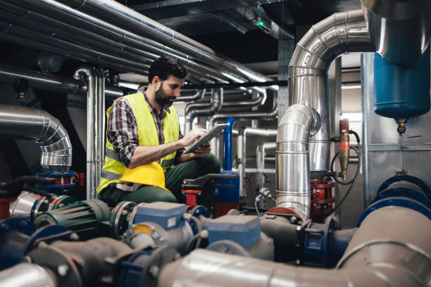 istock Technician engineer man in uniform with tablet checking and control boiler tanks and liquid pipeline in production line at factory 1384290732