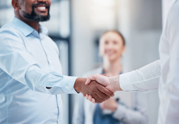 istock Shot of two unrecognizable businesspeople shaking hands in an office at work 1384290744