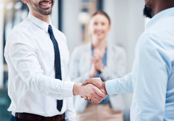 istock Shot of two unrecognizable businesspeople shaking hands in an office at work 1384290763