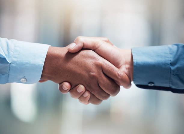 istock Shot of two unrecognizable businesspeople shaking hands in an office at work 1384290773