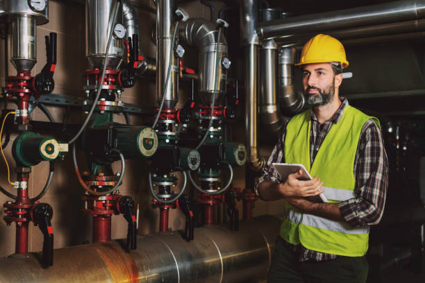 istock Technician engineer man in uniform with tablet checking and control boiler tanks and liquid pipeline in production line at factory 1384290803