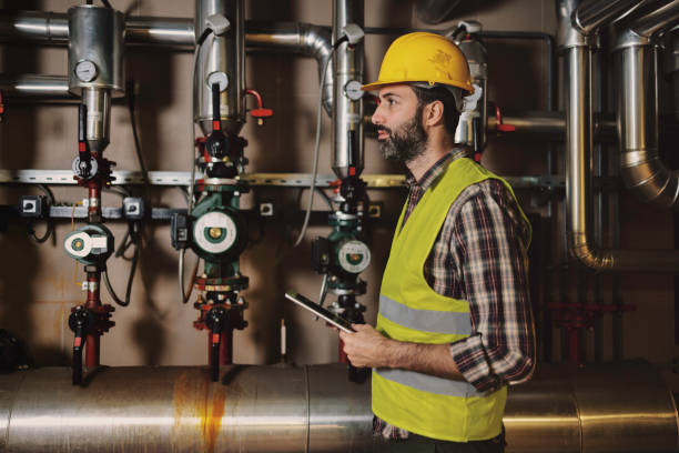 istock Technician engineer man in uniform with tablet checking and control boiler tanks and liquid pipeline in production line at factory 1384290836