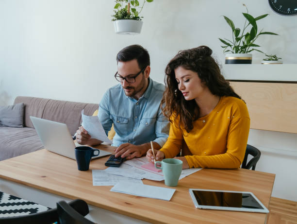 istock Happy Loving Couple Paying Bills at Home 1384295141