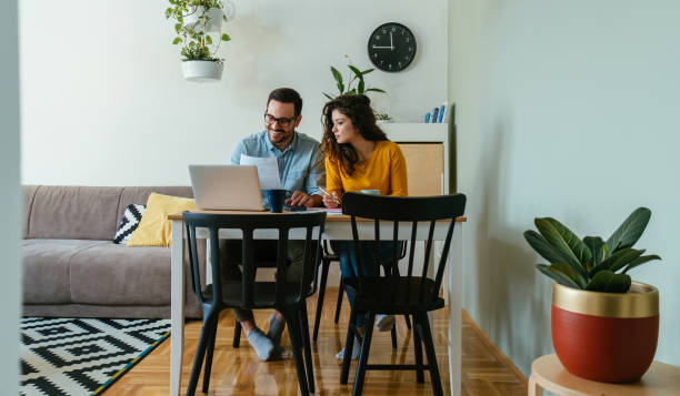istock Happy Loving Couple Paying Bills at Home 1384295143