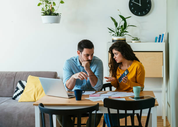 istock Worried Couple Paying Bills Together at Home 1384295149