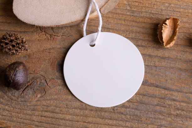 istock Round white tag mockup on a rustic wooden background with cotton string and boho decoration 1384299797