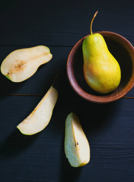 istock pear on the plate and cut pear nearly on the table 1384304960