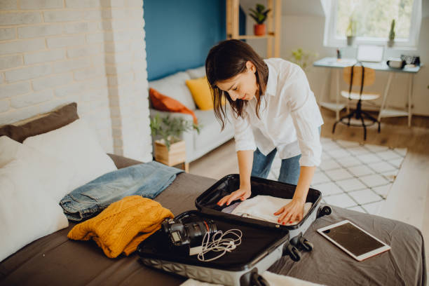 istock Young woman packing her suitcase for a trip 1384311906