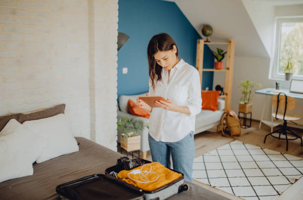 istock Young woman packing her suitcase for a trip 1384311930