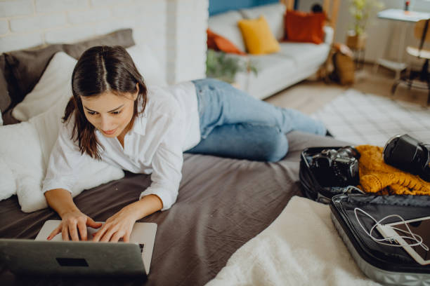 istock Young woman packing her suitcase for a trip 1384312011