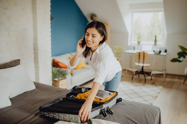 istock Young woman packing her suitcase for a trip 1384312128