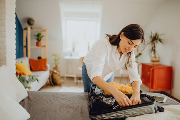 istock Young woman packing her suitcase for a trip 1384312157