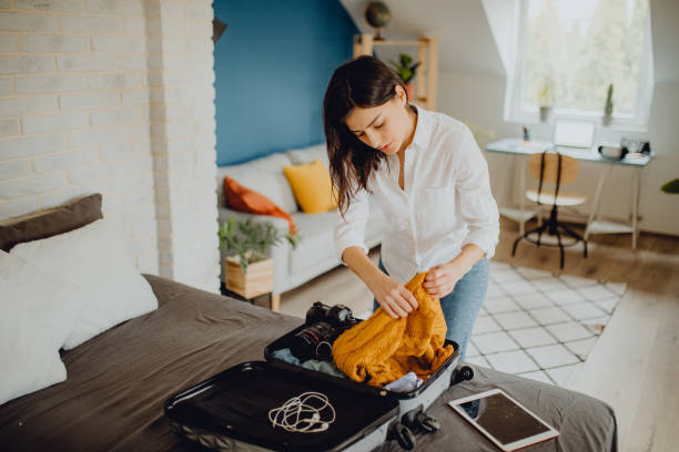 istock Young woman packing her suitcase for a trip 1384312706