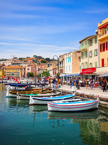 On May 2021, tourists could enjoy a beautiful view on Cassis Harbord and its fishing boats during a sunny day in South of France.