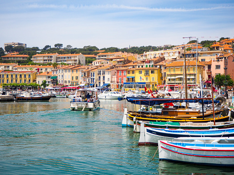 On May 2021, tourists could enjoy a beautiful view on Cassis Harbord and its fishing boats during a sunny day in South of France.