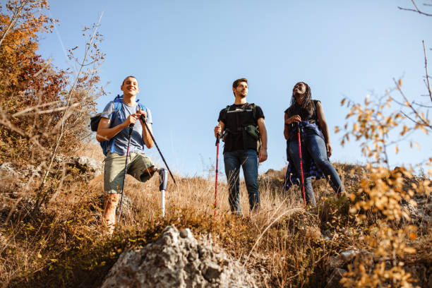 istock Disabled young men with artificial leg going mountain climbing with his friends 1384328343