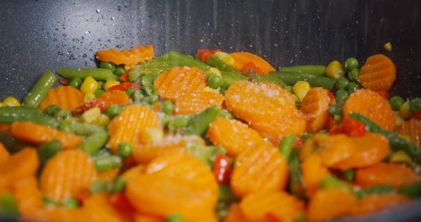istock Season the vegetables cooked in a pan with salt. 1384328556