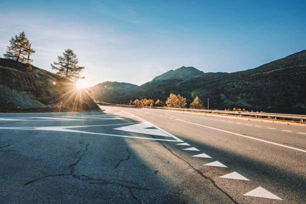 low angle view on simplon pass road in swiss alps in the warm light of the sunset backlit