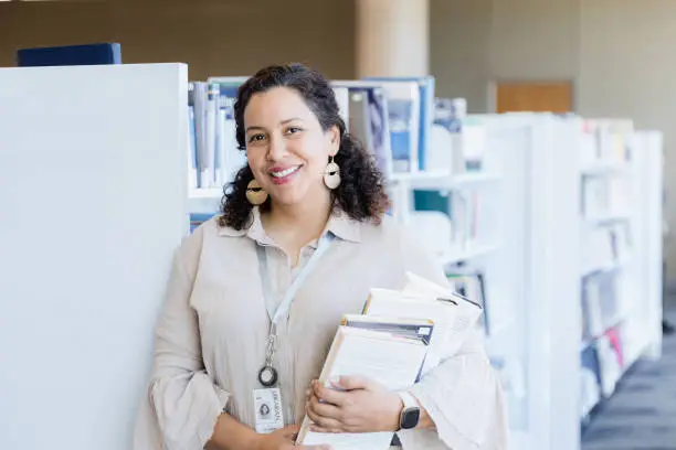 The beautiful woman poses in the school library for her business headshot.