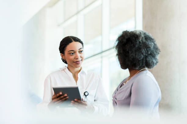 istock Female therapist uses tablet while listening to unrecognizable woman 1384333079