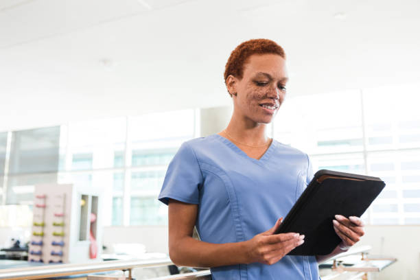 istock Female physical therapist uses digital tablet to plan patient schedule 1384333112