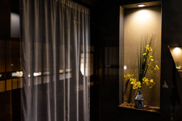 traditional japanese house or ryokan home hotel with yellow flower ikebana in vase decoration decor illuminated by lamp in dark room with curtains at night - door curtain imagens e fotografias de stock