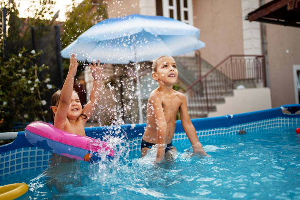 istock Happy children having fun playing games in swimming pool 1384335505