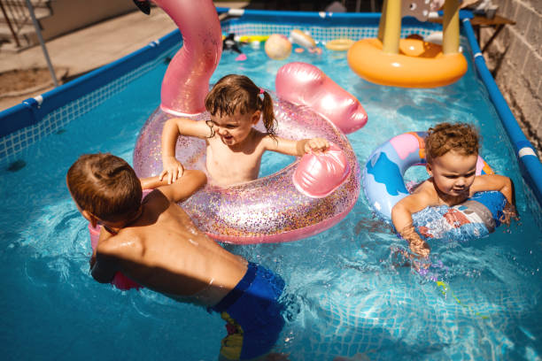 istock Happy children having fun playing games time in swimming pool 1384335626