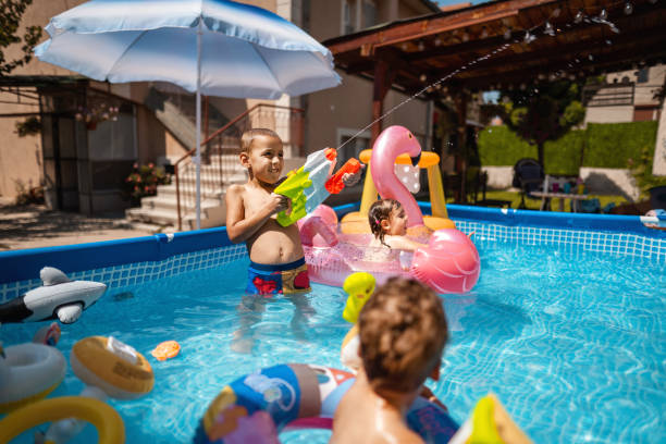 istock Happy children having fun playing games in swimming pool 1384335649