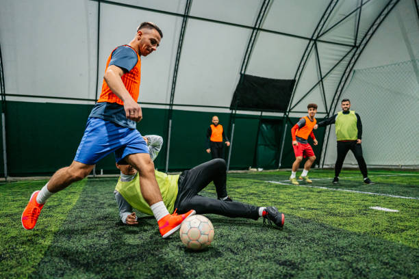 istock Soccer player kicking ball at goal while rival blocking him 1384336048