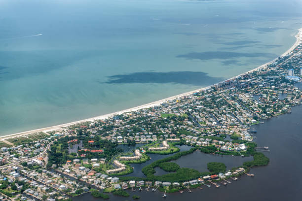 High angle aerial view of Ft Myers beach landscape near Sanibel Island in southwest in Florida Saharan with beautiful green water and houses buildings High angle aerial view of Ft Myers beach landscape near Sanibel Island in southwest in Florida Saharan with beautiful green water and houses buildings fort myers beach photos stock pictures, royalty-free photos & images