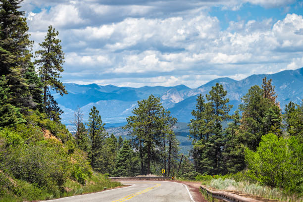Carson National Forest highway 76 with Sangre de Cristo mountains in background with green pine tree forest in summer at high road to Taos
