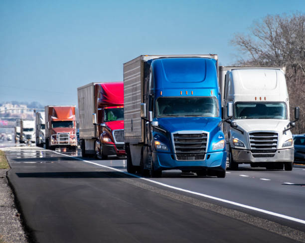 istock Long Convoy of Trucks on Interstate Highway 1384341495