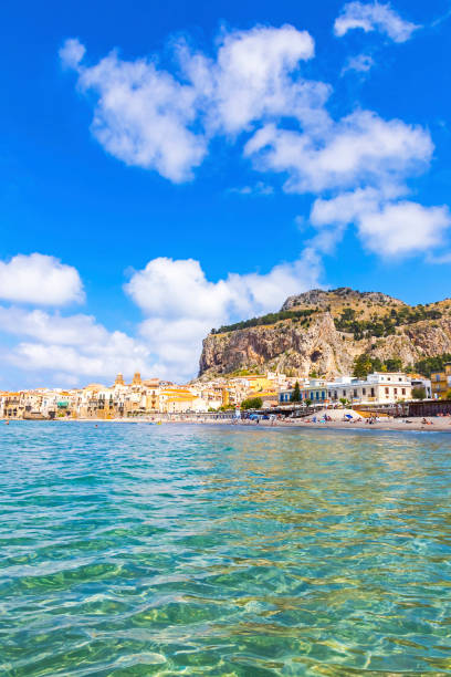 Cefalu beach, Cefalu town, Sicily, Italy Azure water of Mediterranean sea at Cefalu beach, Cefalu town, Sicily, Italy. One of the best beach on Sicily. Mount La Rocca di Cefalu on background cefalu stock pictures, royalty-free photos & images