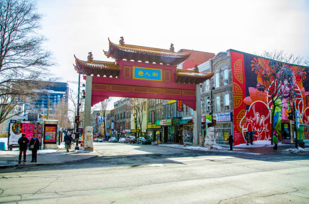 People waiting to cross street besides Montreal Chinatown gate during winter day