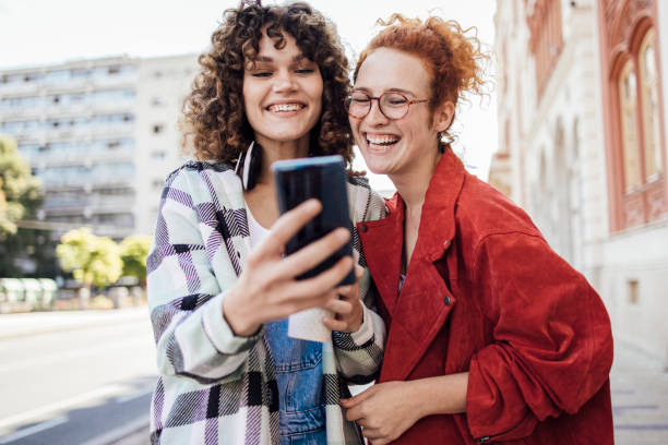 istock Two girls using smartphone on the move and having fun 1384369427