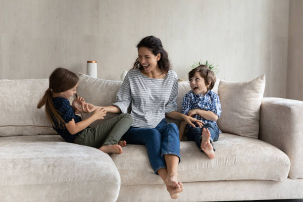 istock Woman and kids playing sit on sofa at home 1384369496