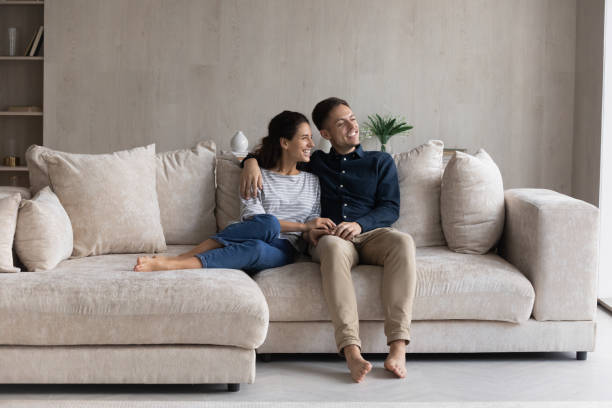 istock Peaceful couple relaxing on comfortable couch looking out window 1384369512