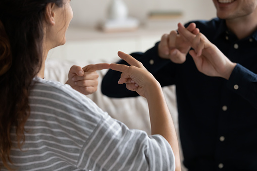 Pareja comunicándose en casa usando lenguaje de señas, primer plano photo