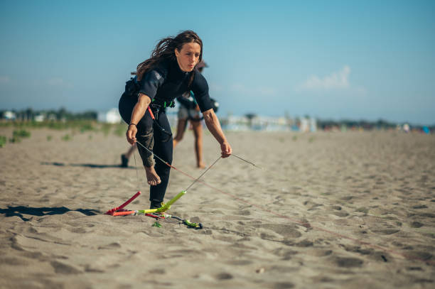 istock Woman using flying lines and a control bar for kitesurfing 1384369865