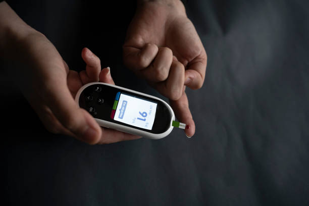 istock Caucasian young woman using digital glucometer at home. 1384382502