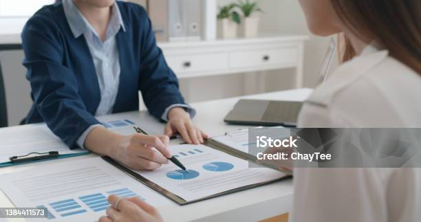 Asia Stock Trader Agent Or Sale Tax Loan Broker Advice Brief And Point Hand To Graph Report Talk To Client At Office Desk Show Budget Chart Data Or Legal Result On Claim Form Trust Will In Work Plan Stock Photo - Download Image Now