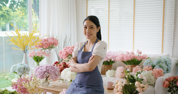 Asia people young woman SME owner happy smile arms crossed look camera enjoy open flower shop work at home office workspace. Loan money banking for online store seller. Girl power pride in sale order.
