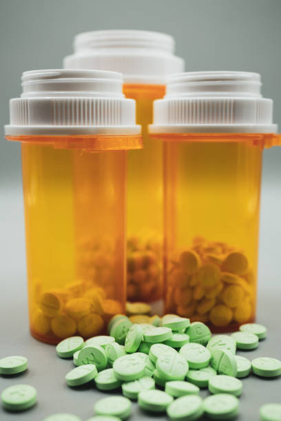 trois flacons d’ordonnance avec des pilules vertes - pill bottle prescription medicine cabinet bottle photos et images de collection