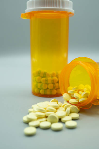 istock Prescription Bottle with Yellow Pills Spilling Out 1384419230