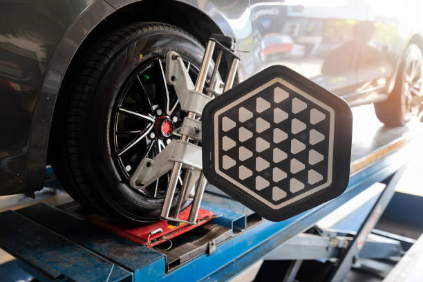 Car wheel balancer calibrate with laser reflector attach on each tire to center driving adjust. Car in auto service. Balancing tire wheel machine. stock photo