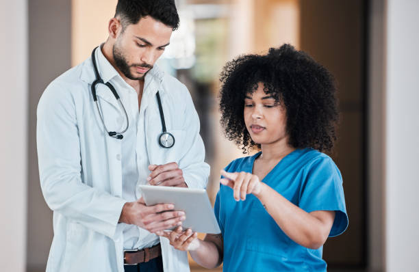 istock Shot of two young doctors using a tablet and having a discussion in a modern office 1384434690